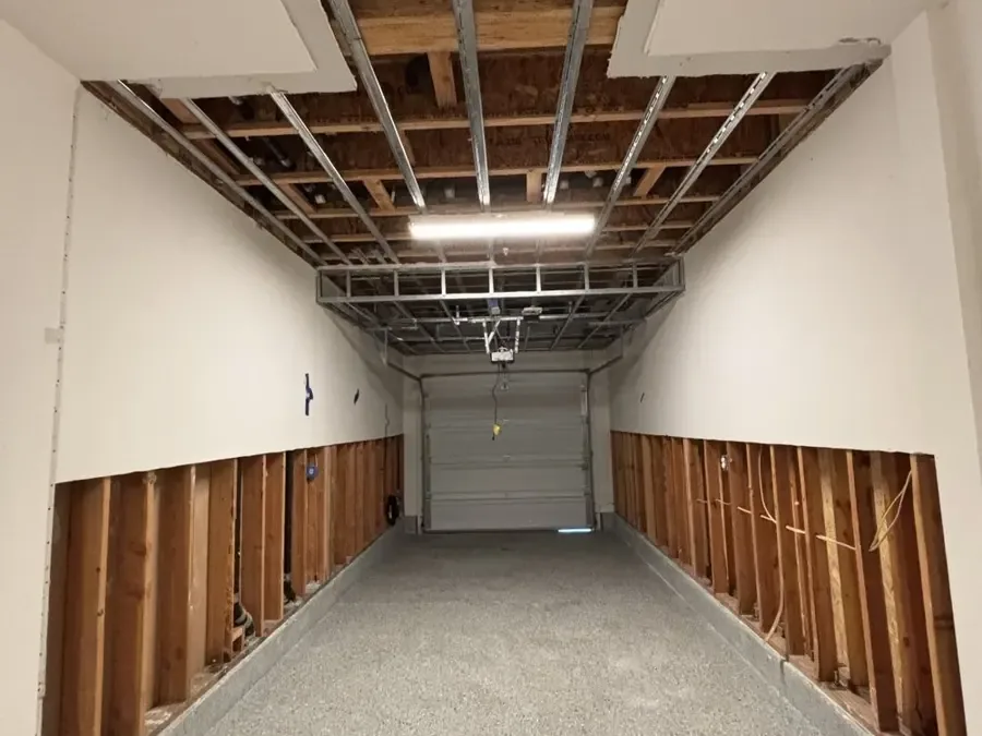 Flood cuts along both garage walls after a water heater leaked
