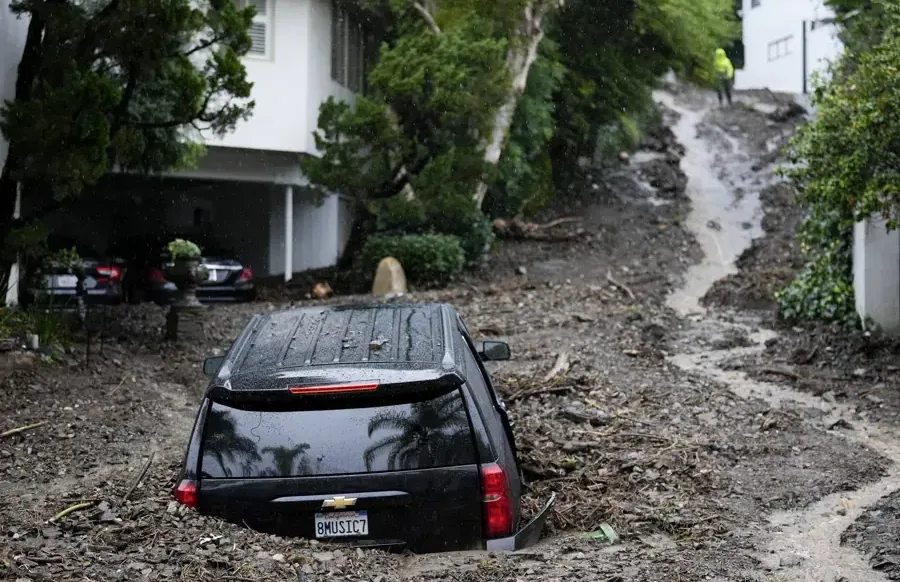 Mud and storm runoff around a car on a foothill street after a flash flood