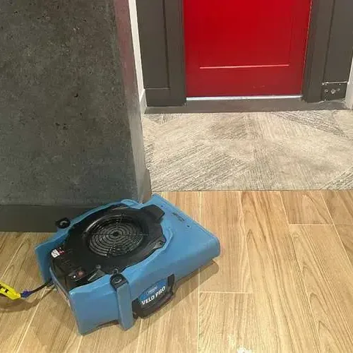 One air mover blowing across a wood-look tile floor near an open doorway