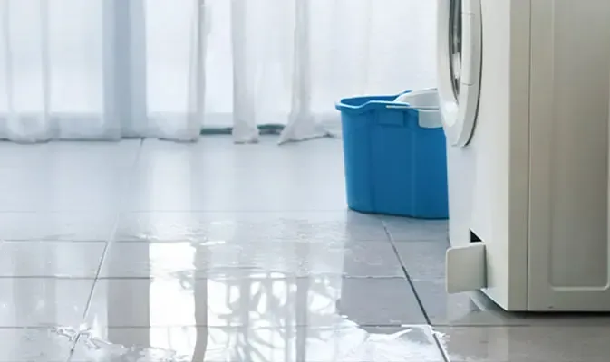 Water spread over a tile floor from a leaking washing machine
